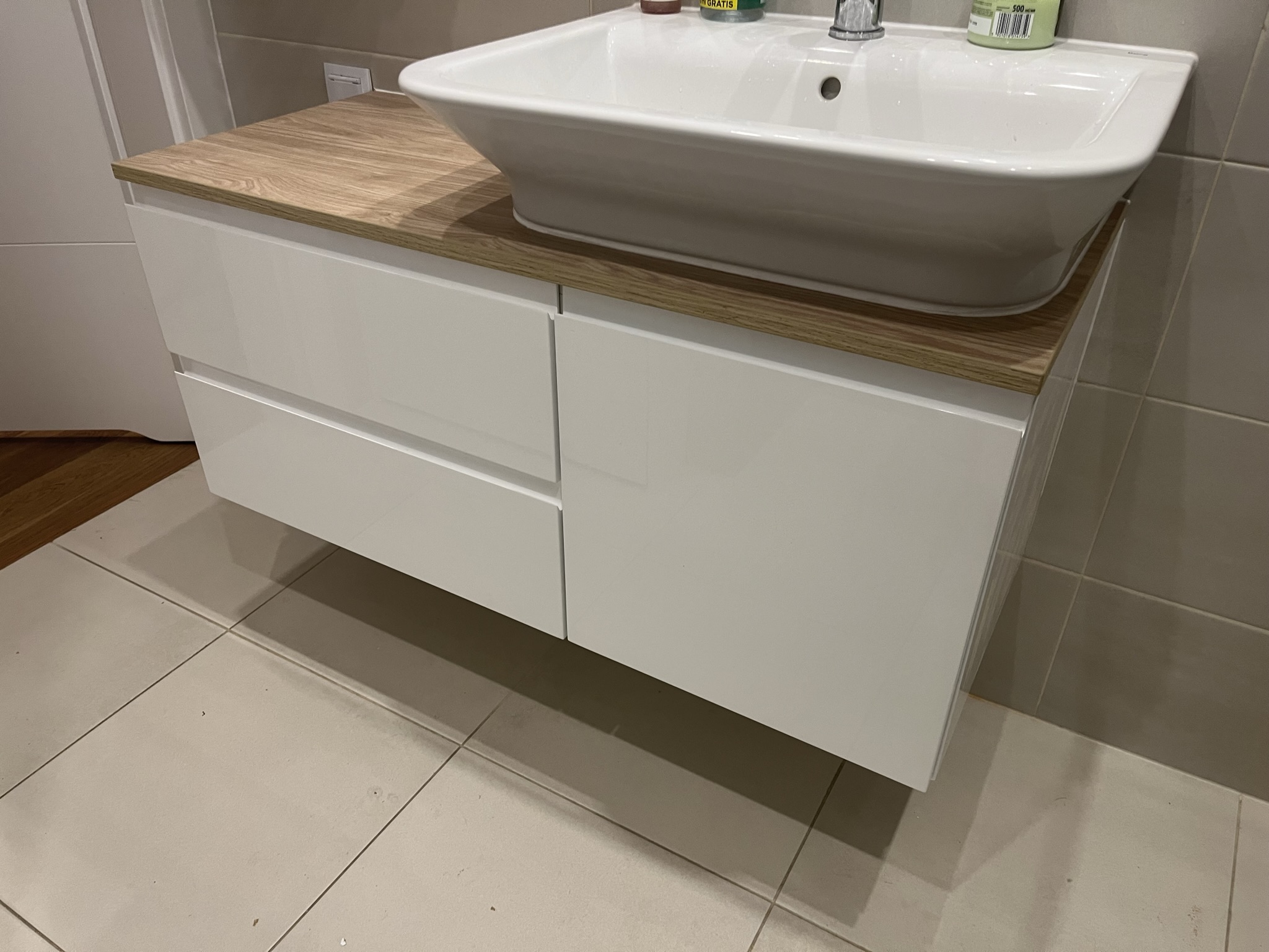 mebel łazienkowy - biała umywalka z drewnopodobnym blatem